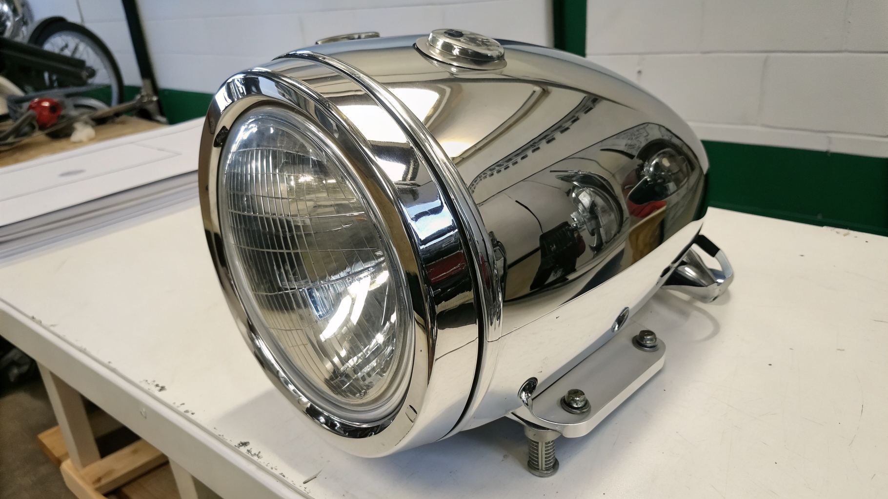 Freshly chrome plated motorcycle exhaust and headlamp shell with a mirror finish after restoration